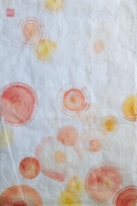 Kreise in warmen Rot- und Gelbtönen schweben in zarter Tuschemalerei über hellem Grund, ein lichtvolles Sumi-e Spiel der Farben.